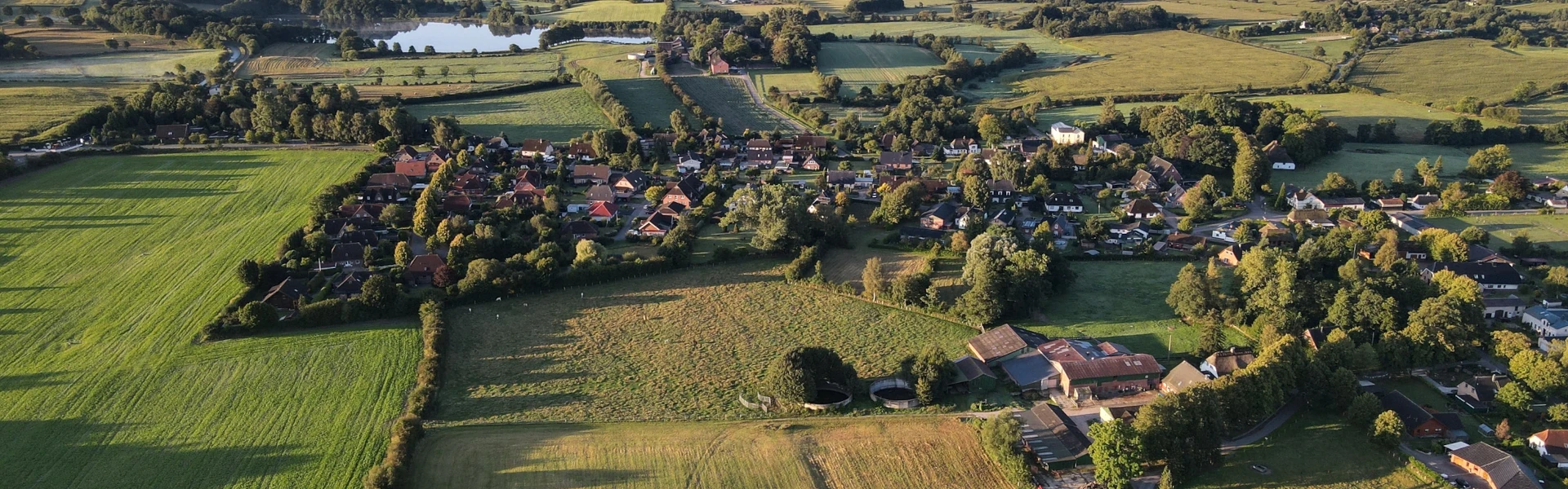 Drohnenaufnahme von Havetoft, Meiereistraße, Dorfstaße, Sandstraße, im Hintergrund der Havetofter See